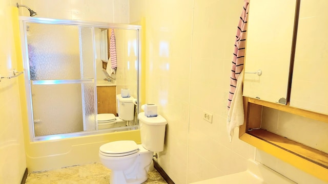 bathroom featuring tile flooring, tile walls, toilet, and enclosed tub / shower combo