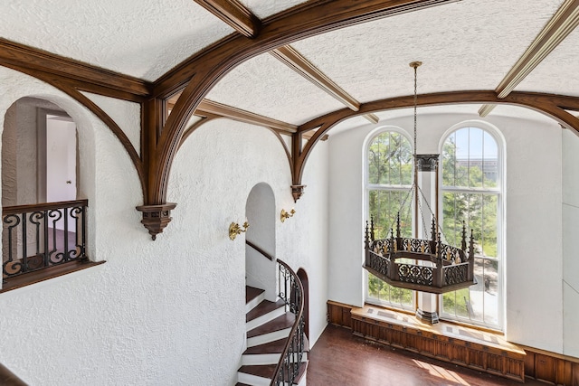 entryway with a wealth of natural light, dark wood-type flooring, and a textured ceiling