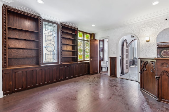 living room featuring ornamental molding, dark wood-type flooring, and built in shelves