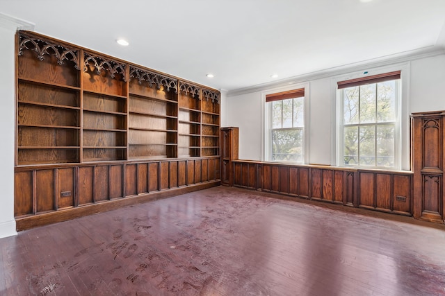 unfurnished room featuring built in features, dark hardwood / wood-style flooring, and crown molding