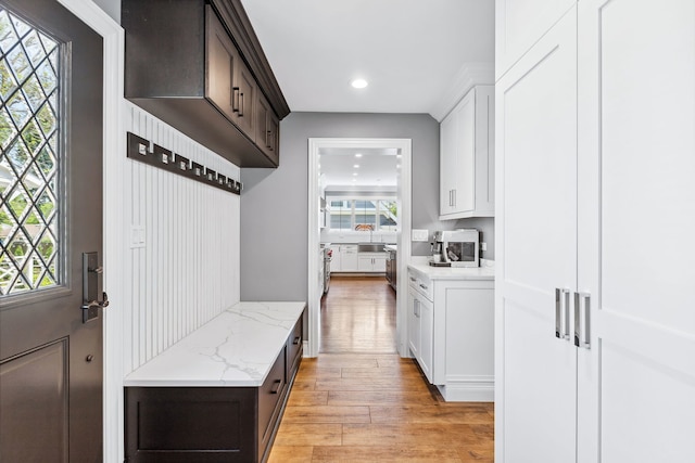 mudroom with sink and light hardwood / wood-style flooring