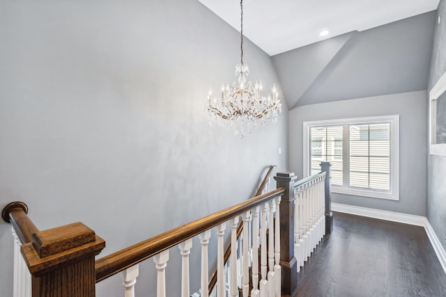 hall featuring a notable chandelier, dark wood-type flooring, and high vaulted ceiling