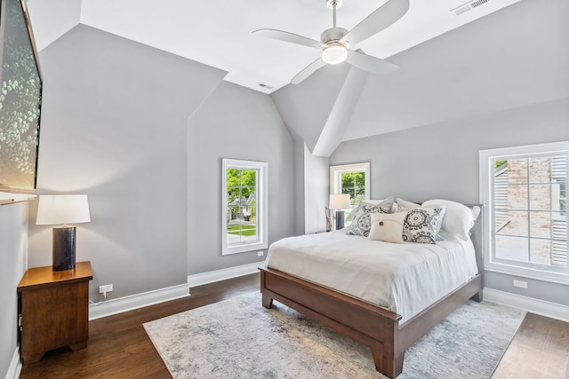 bedroom with lofted ceiling, ceiling fan, dark hardwood / wood-style floors, and multiple windows