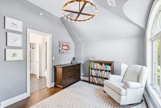 living area featuring a notable chandelier, vaulted ceiling, and tile floors