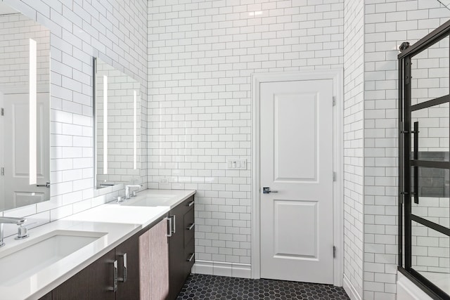 bathroom with dual sinks, tile flooring, vanity with extensive cabinet space, and tile walls