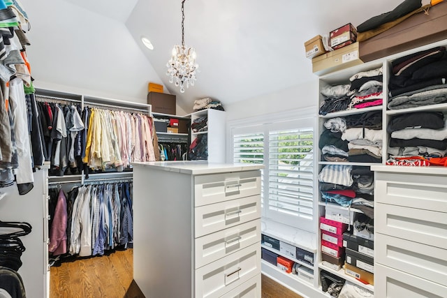 walk in closet with a chandelier, light hardwood / wood-style flooring, and lofted ceiling