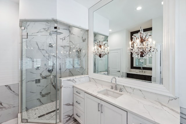 bathroom featuring a shower with shower door, vanity, and an inviting chandelier