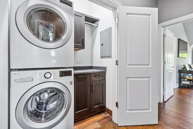 washroom with stacked washer and clothes dryer and light hardwood / wood-style flooring