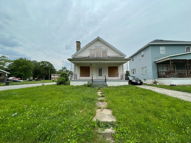 bungalow-style house with a front yard and covered porch