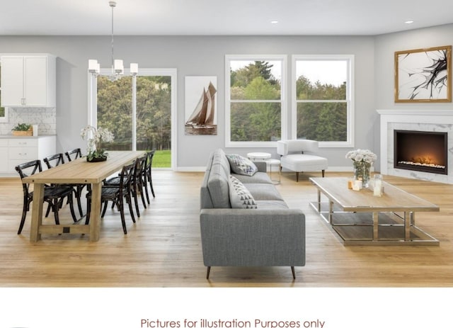 living room featuring light wood-type flooring and a notable chandelier