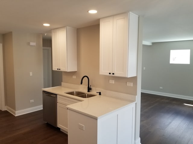 kitchen featuring dishwasher, sink, white cabinetry, and dark hardwood / wood-style floors