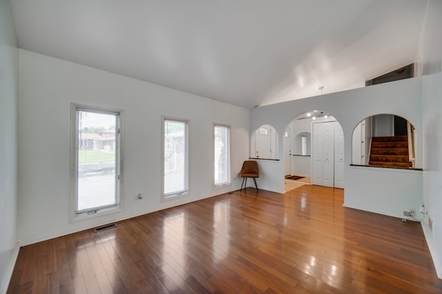 unfurnished living room featuring lofted ceiling and hardwood / wood-style flooring