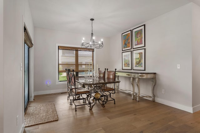 dining space featuring hardwood / wood-style floors and a chandelier