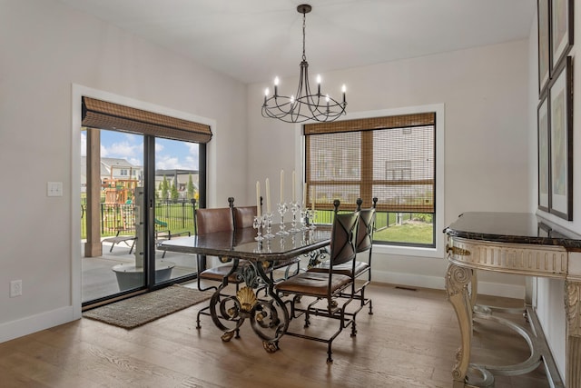 dining area featuring hardwood / wood-style flooring and a chandelier