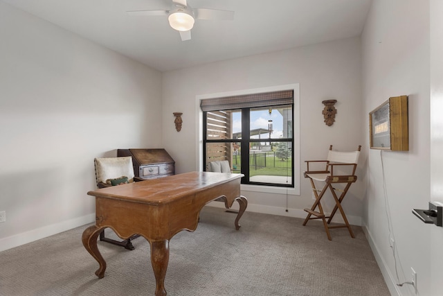 carpeted home office featuring ceiling fan