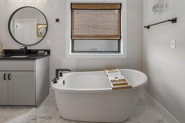 bathroom featuring tile floors, vanity, and a bath to relax in