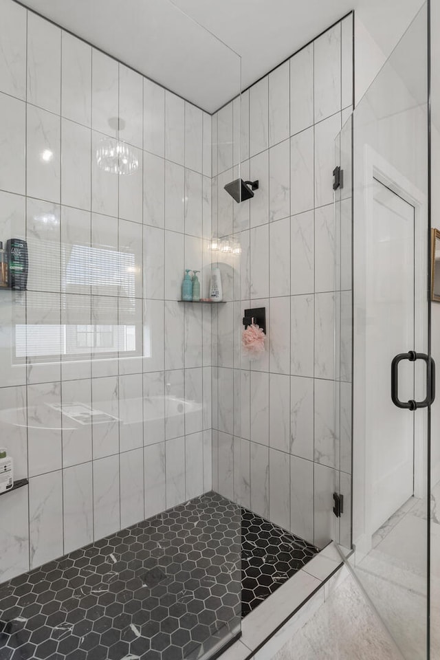 bathroom featuring a shower with shower door and tile flooring