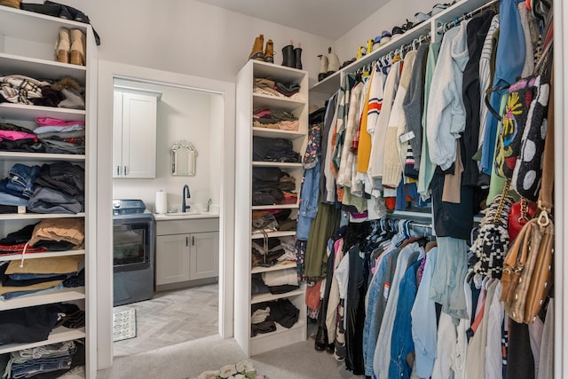 walk in closet featuring light carpet and sink