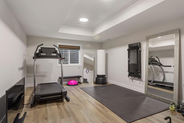 workout area featuring hardwood / wood-style flooring and a raised ceiling