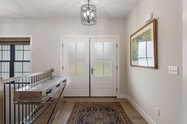 foyer with a notable chandelier, hardwood / wood-style flooring, and french doors