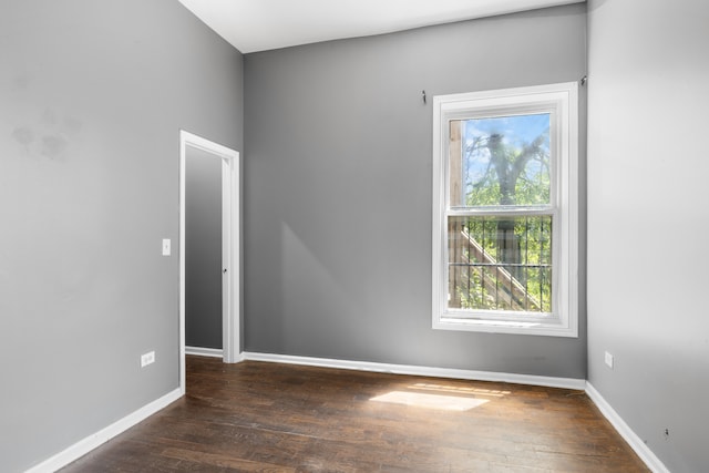 unfurnished room with dark hardwood / wood-style flooring