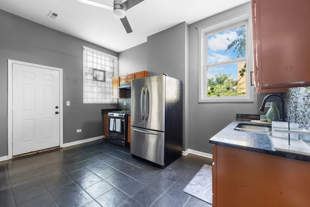 kitchen featuring dark tile floors, backsplash, ceiling fan, appliances with stainless steel finishes, and ventilation hood