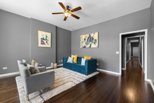 living room with ceiling fan and dark hardwood / wood-style flooring