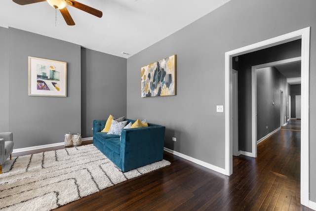 living area featuring dark wood-type flooring and ceiling fan