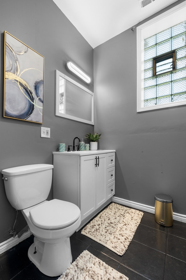 bathroom with tile flooring, large vanity, and toilet