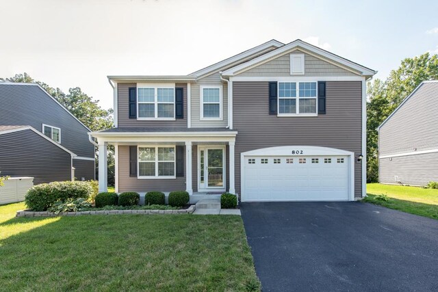 view of property featuring a garage and a front yard