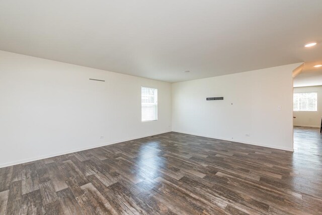 spare room featuring a wealth of natural light and dark wood-type flooring