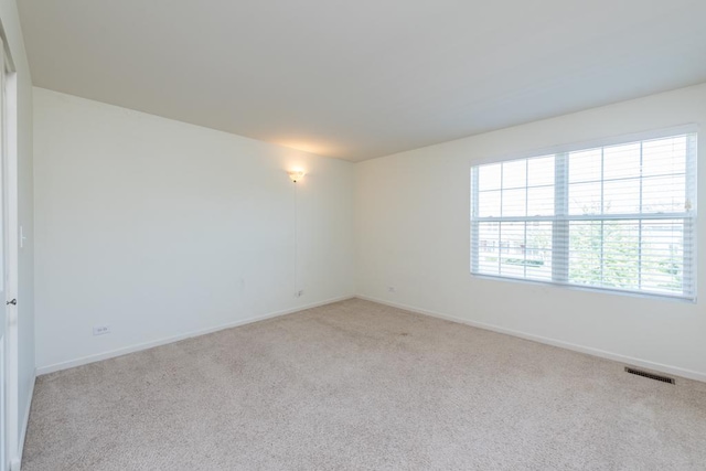 unfurnished room featuring light carpet, baseboards, and visible vents