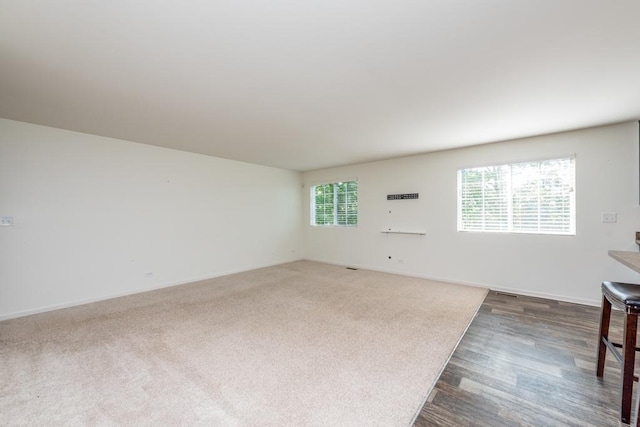 unfurnished living room featuring dark wood-style floors and baseboards