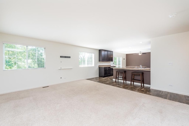 living room featuring a ceiling fan, dark carpet, and baseboards