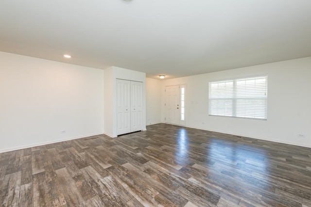 unfurnished room featuring dark wood-style flooring and baseboards