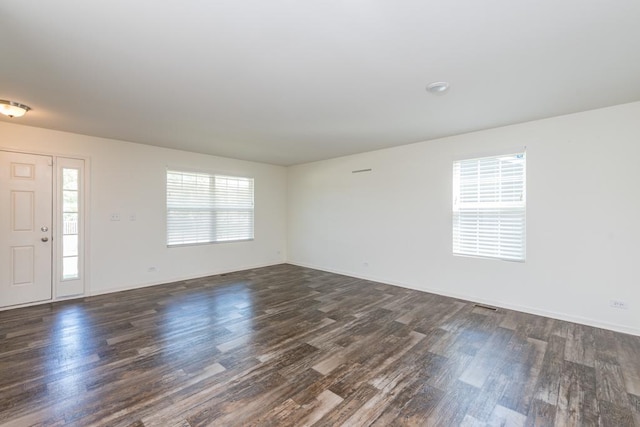 unfurnished room with dark wood-style flooring and baseboards