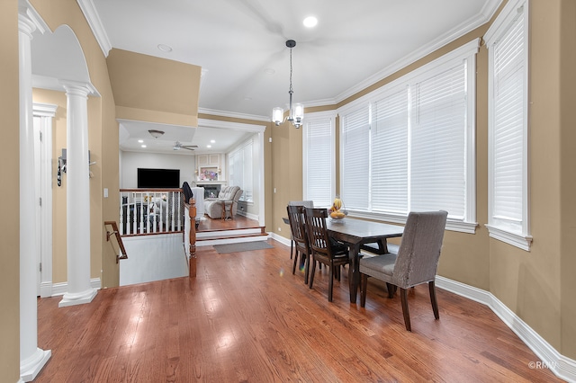 dining area featuring crown molding, hardwood / wood-style floors, and ornate columns