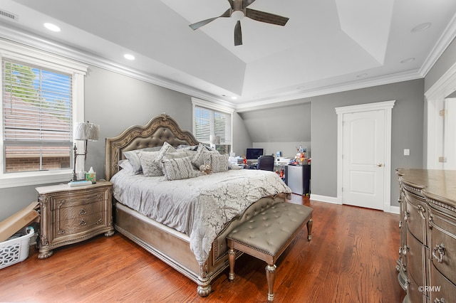 bedroom with a raised ceiling, ceiling fan, crown molding, and wood-type flooring