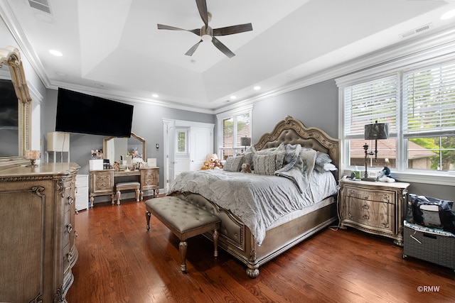 bedroom with crown molding, dark wood-type flooring, ceiling fan, and a raised ceiling