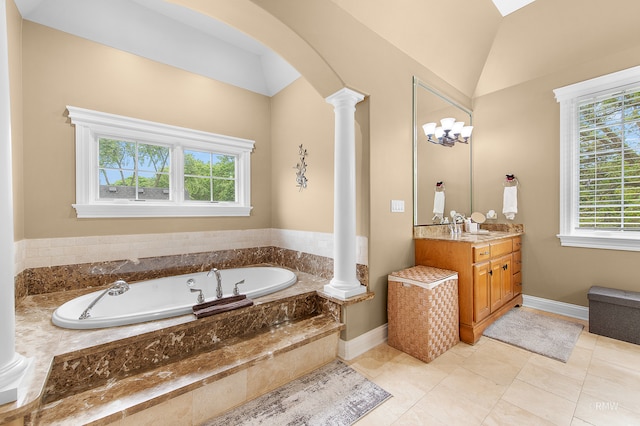 bathroom with tile floors, ornate columns, tiled bath, vanity, and lofted ceiling