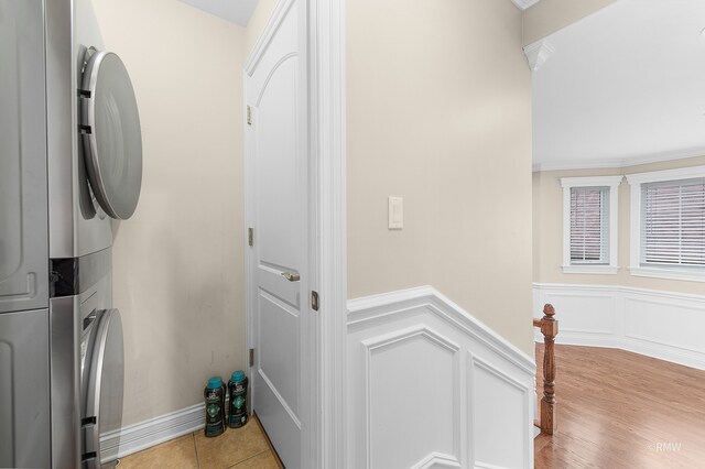 washroom featuring stacked washer and clothes dryer and light hardwood / wood-style floors