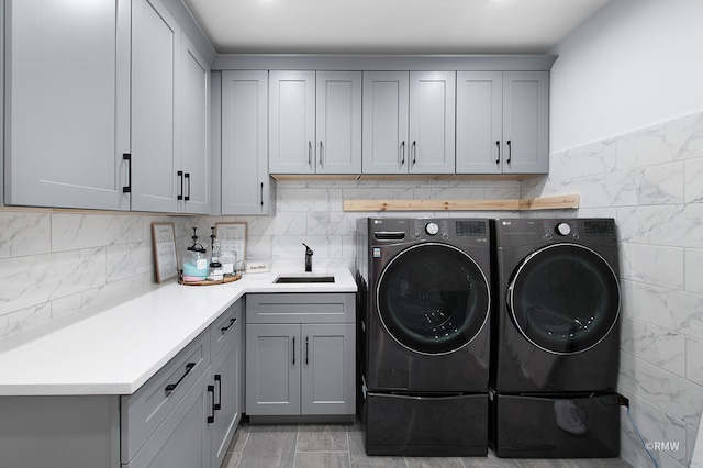 laundry room featuring cabinets, sink, washer and clothes dryer, and light tile floors