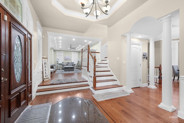 entrance foyer with hardwood / wood-style flooring, decorative columns, and a raised ceiling