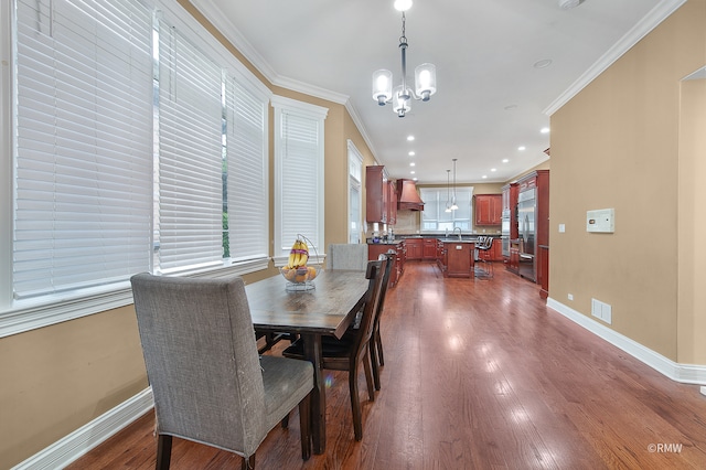 dining room featuring crown molding, sink, dark hardwood / wood-style floors, and a chandelier