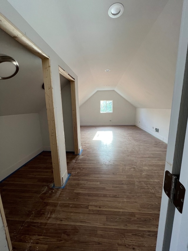 additional living space featuring dark hardwood / wood-style flooring and lofted ceiling