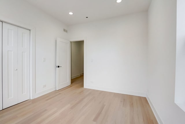 unfurnished bedroom featuring a closet and light wood-type flooring