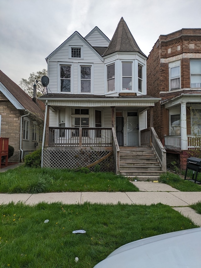 victorian-style house featuring a front lawn and covered porch