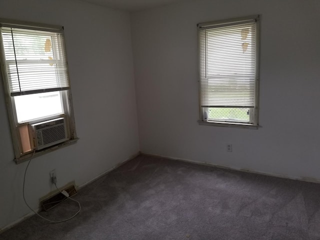 carpeted empty room with cooling unit and a healthy amount of sunlight