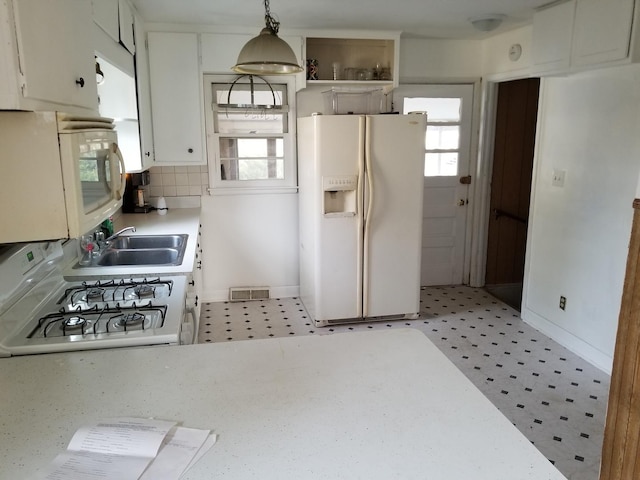 kitchen with sink, hanging light fixtures, white appliances, decorative backsplash, and white cabinets