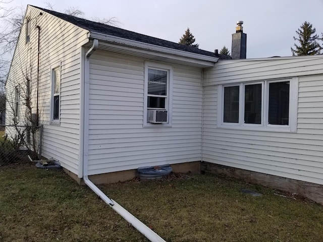 view of side of property with cooling unit and a yard